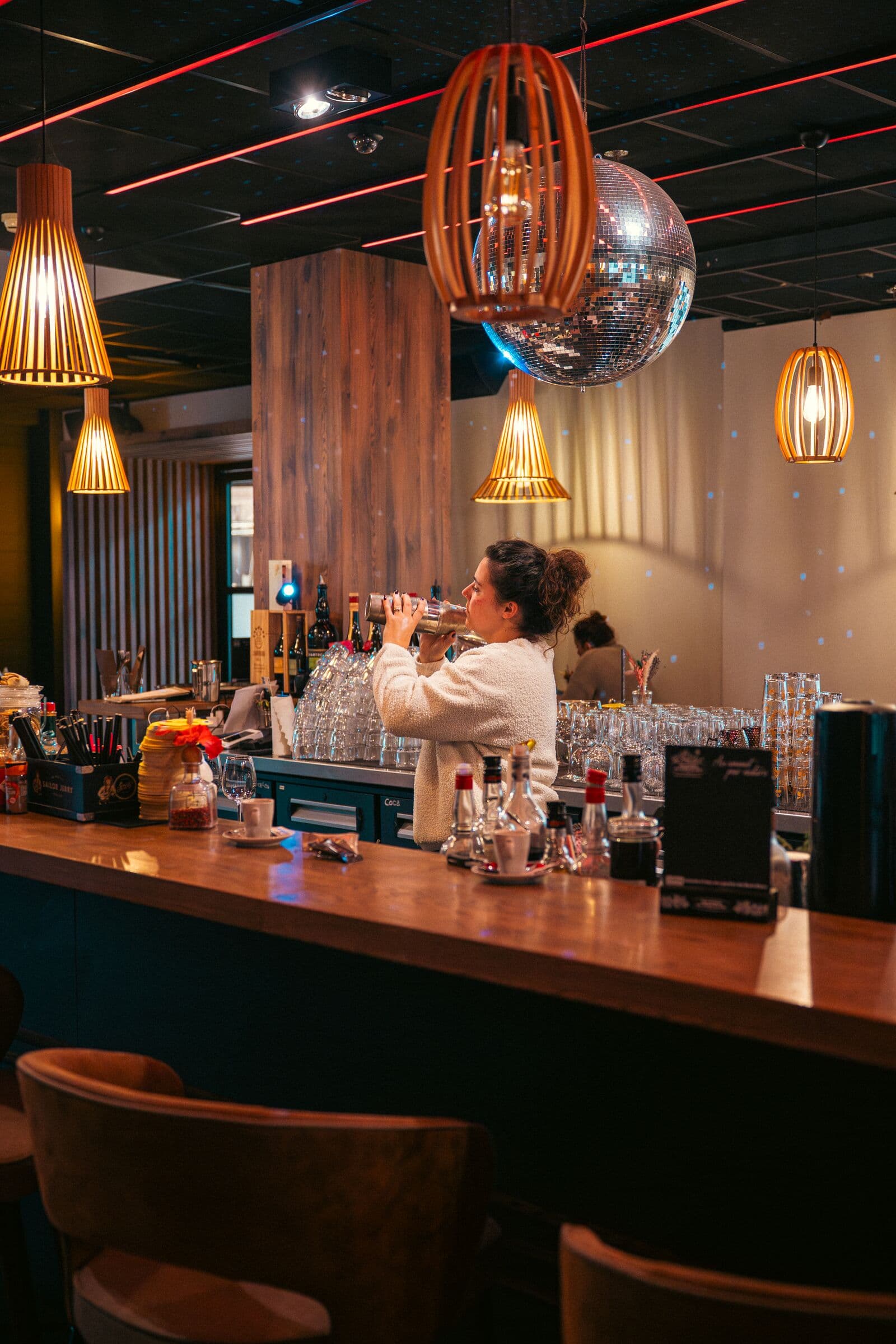 Le bar à cocktails du WOODS, néons rouges et boule à facettes
