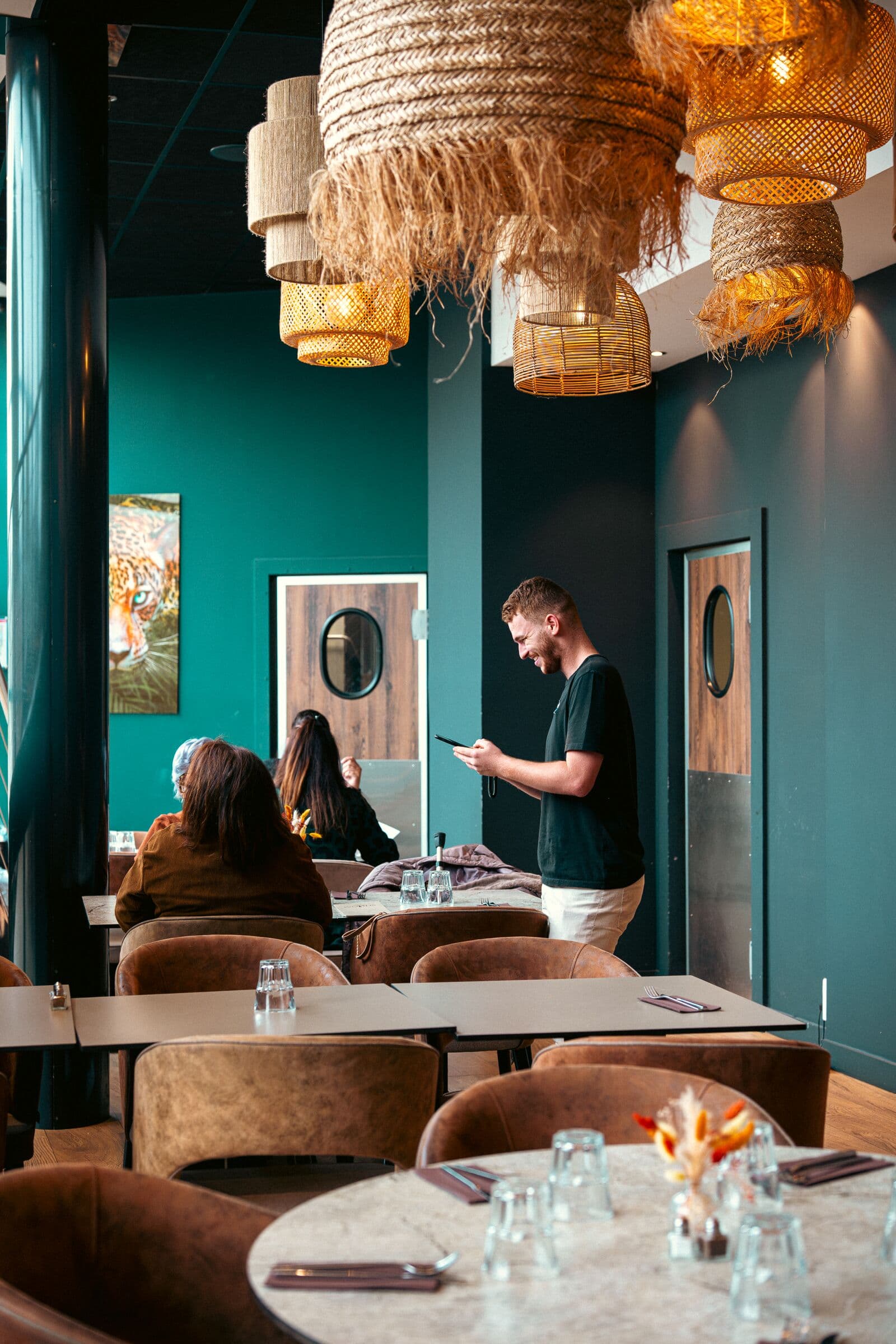 Salle aux murs bleu canard et banquettes en velours au WOODS