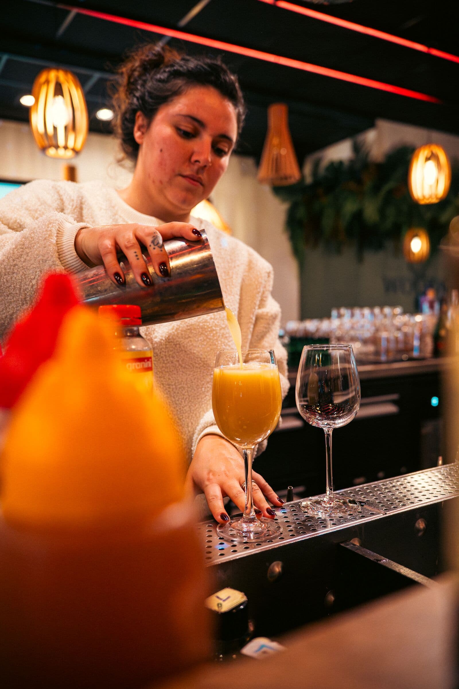 Barmaid versant un cocktail au shaker