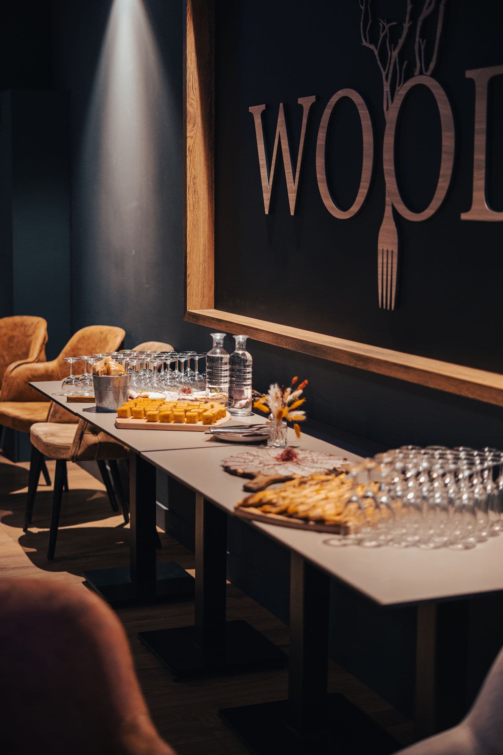 Grande table dressée pour un groupe devant le logo du WOODS